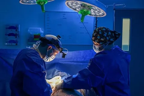 Reducción de senos en Turquía: cirujano plástico y equipo quirúrgico durante una reducción de pecho en el quirófano