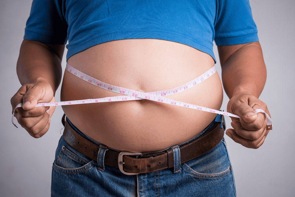 overweight fat adult man very tight jeans with measuring tape إزالة الكرش
